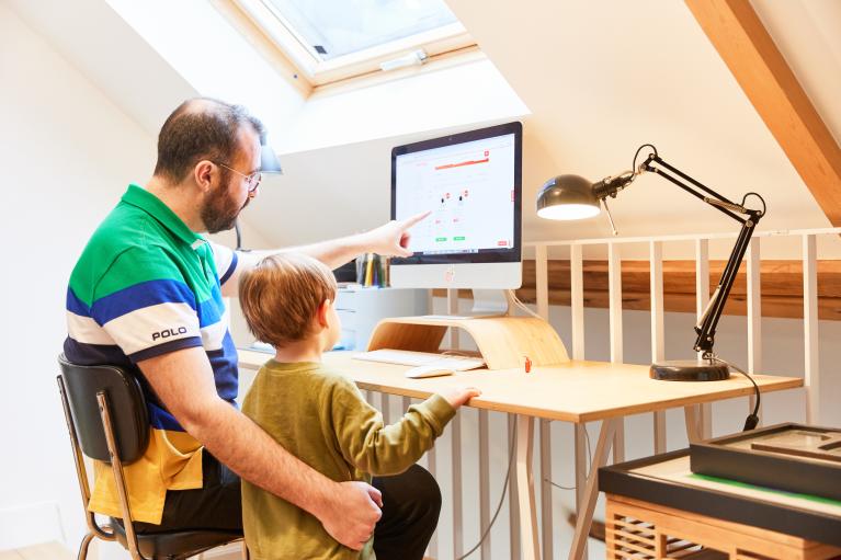 Un homme et son fils parcourant le web à la maison